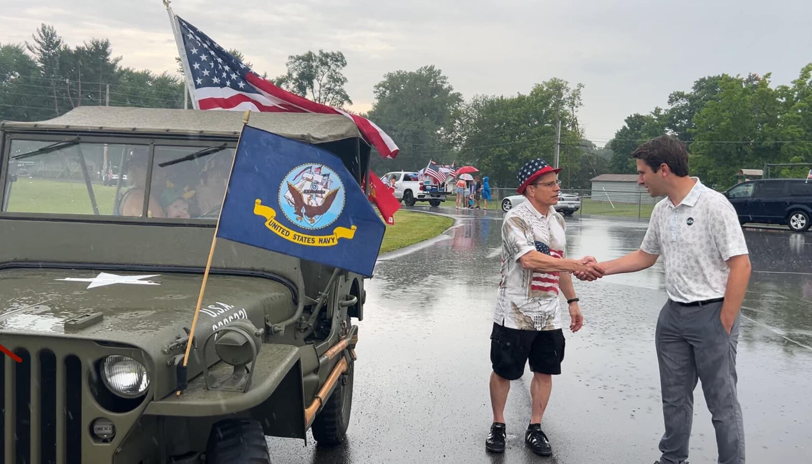 Andrew Ireland greeting a veteran at a rainy community parade