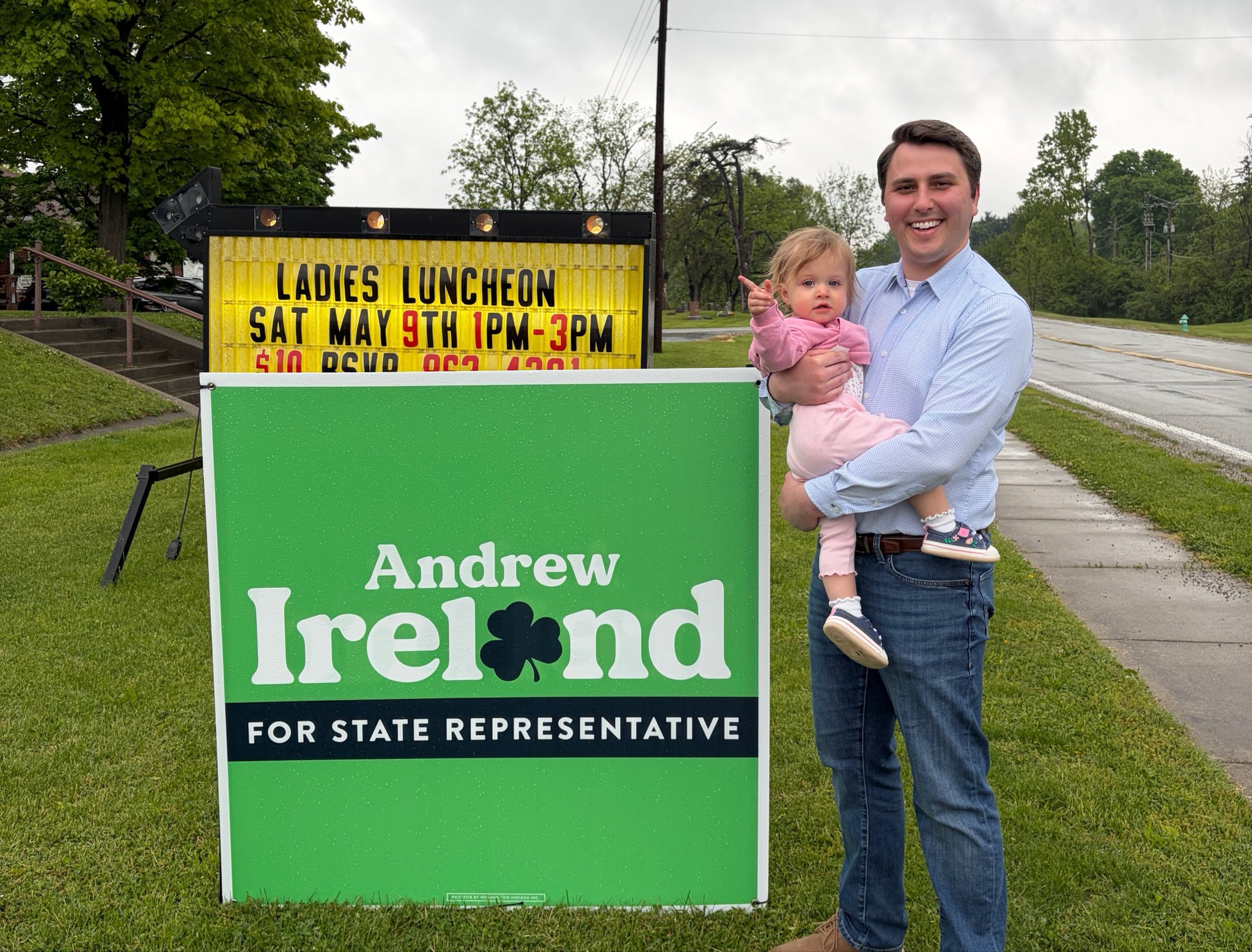 Andrew Ireland and his daughter Anna Grace beside an Ireland campaign yard sign